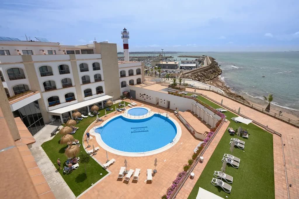 Piscina y faro de un hotel de HACE en Cádiz, vistos desde arriba
