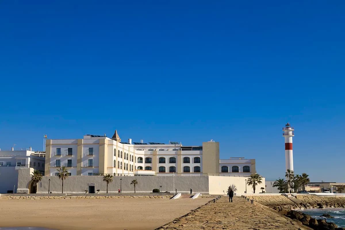 Fachada de un hotel de HACE frente al mar en Cádiz, con faro y playa